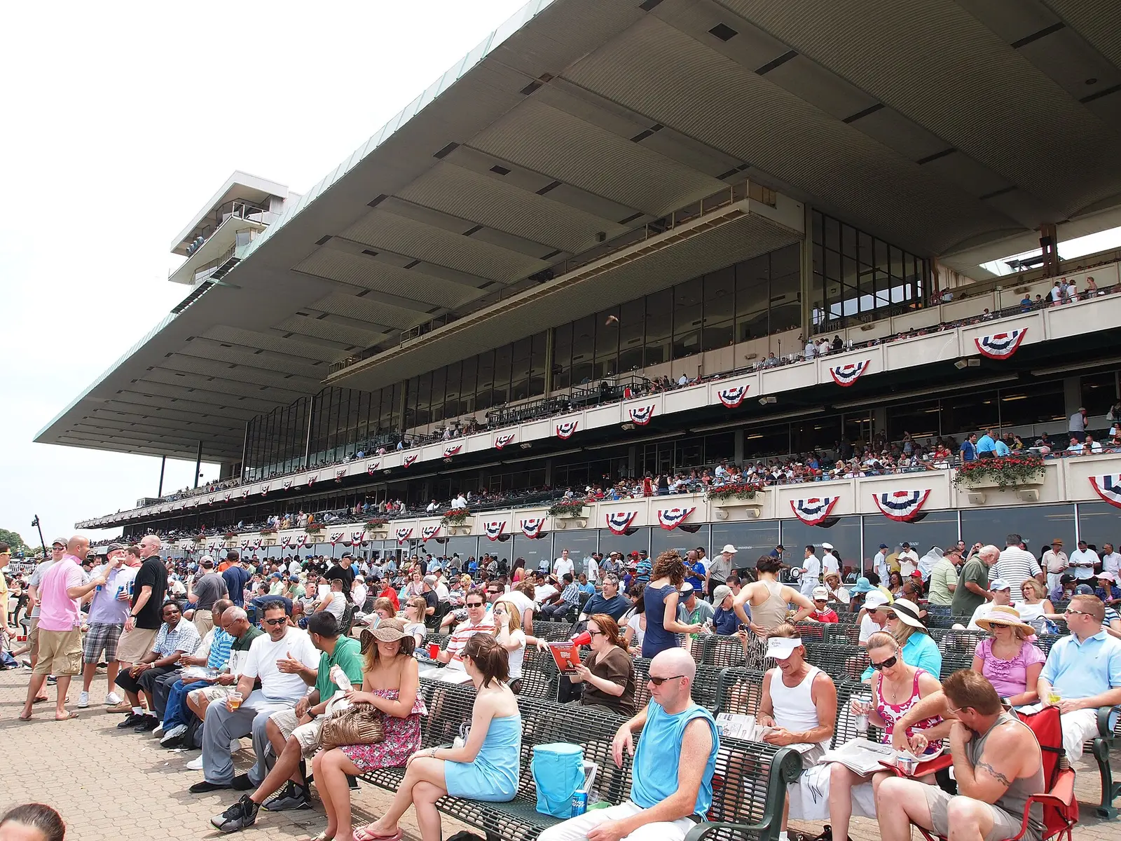 Crowd in front of the long grandstand at Belmont Park on Belmont Stakes day, New York
